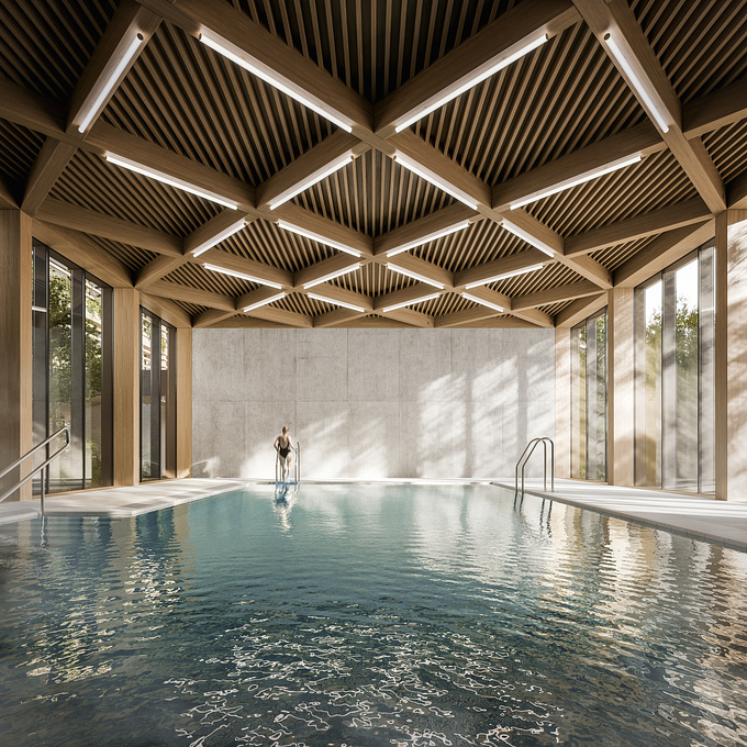 A person swims in a modern indoor pool with wooden ceiling. 