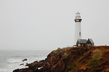 White lighthouse on rocky cliff