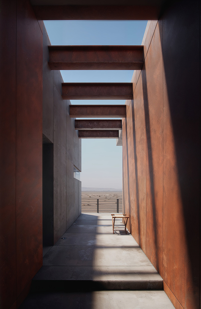 A terrace corridor crafted from Corten metal panels blends seamlessly with the desert landscape through the endless desert.