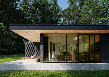 Modern single-story house with large glass windows and a wooden deck